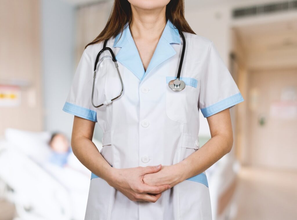 A diverse group of healthcare professionals wearing various uniforms in a hospital setting, showcasing professionalism and teamwork.