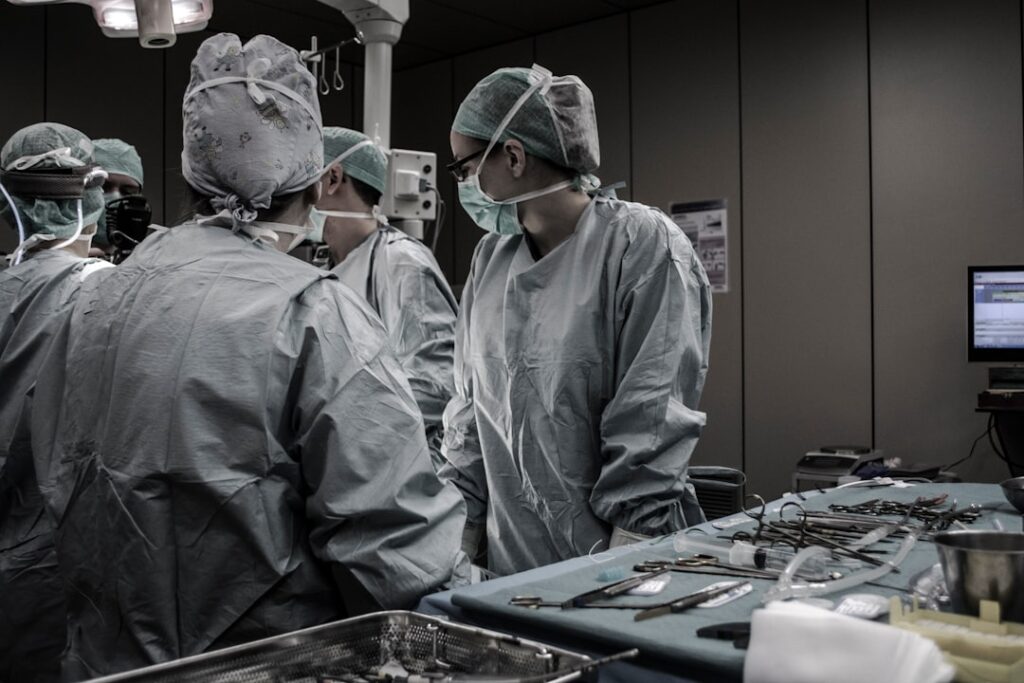 A neatly arranged set of medical uniforms including scrubs, lab coats, and accessories on a clean surface, symbolizing preparation for a new job.