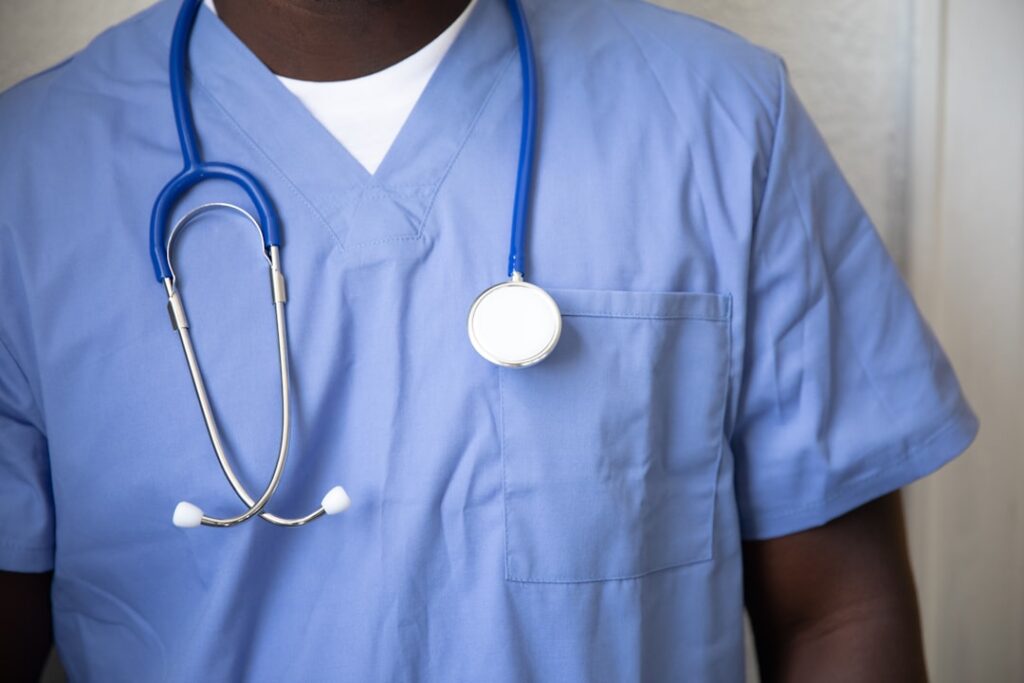 A variety of medical scrubs displayed on hangers, showcasing different sizes and styles suitable for petite, tall, and plus-size professionals.