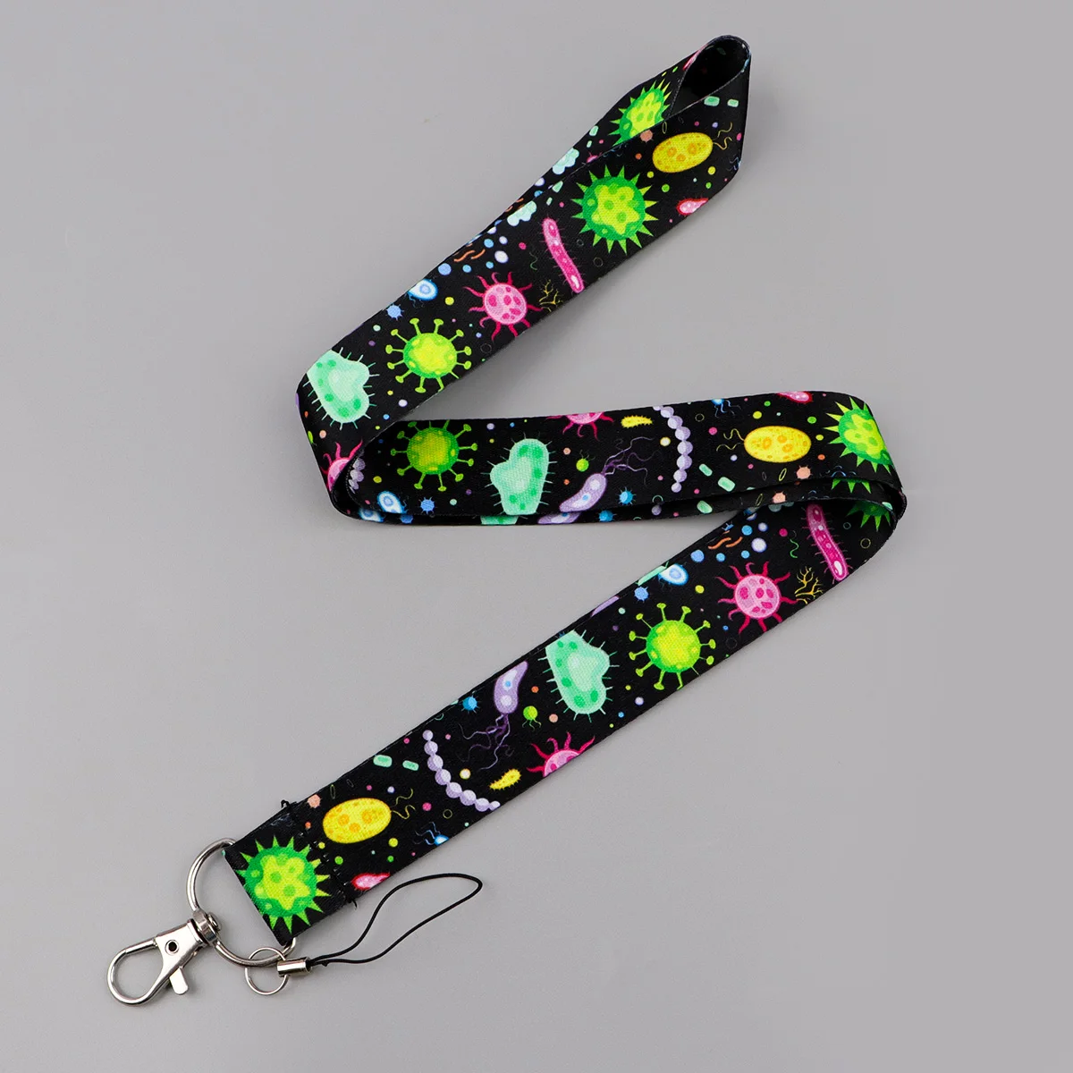 {title} — colorful bacteria and animal print polyester neck lanyard shown with a badge and keyring – view 3