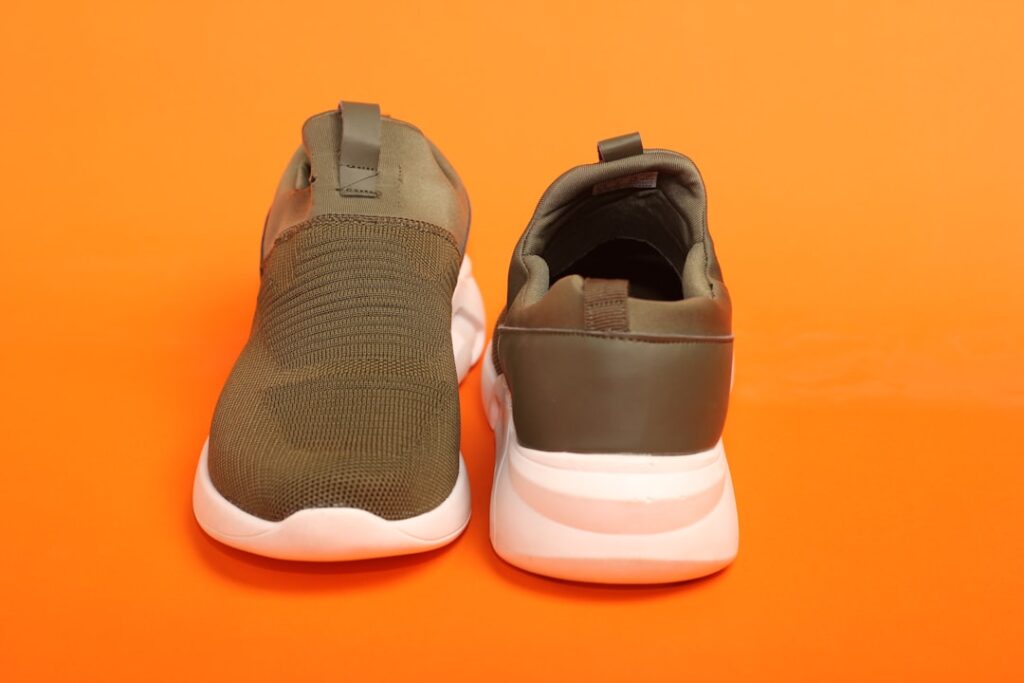 A pair of slip-resistant shoes designed for healthcare professionals, placed on a hospital floor with a clinical environment in the background.